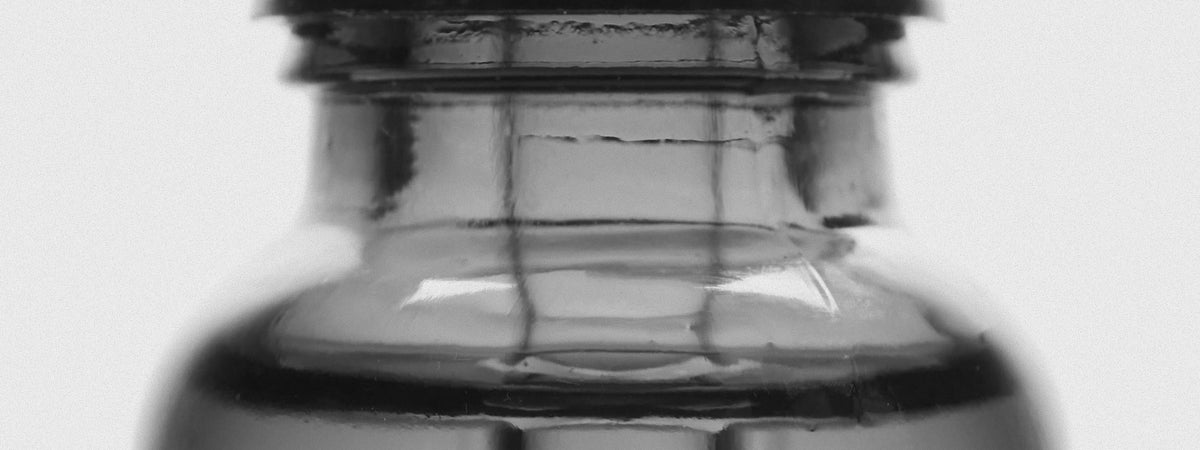 Close-up of the neck and shoulder of a dark glass bottle, black and white