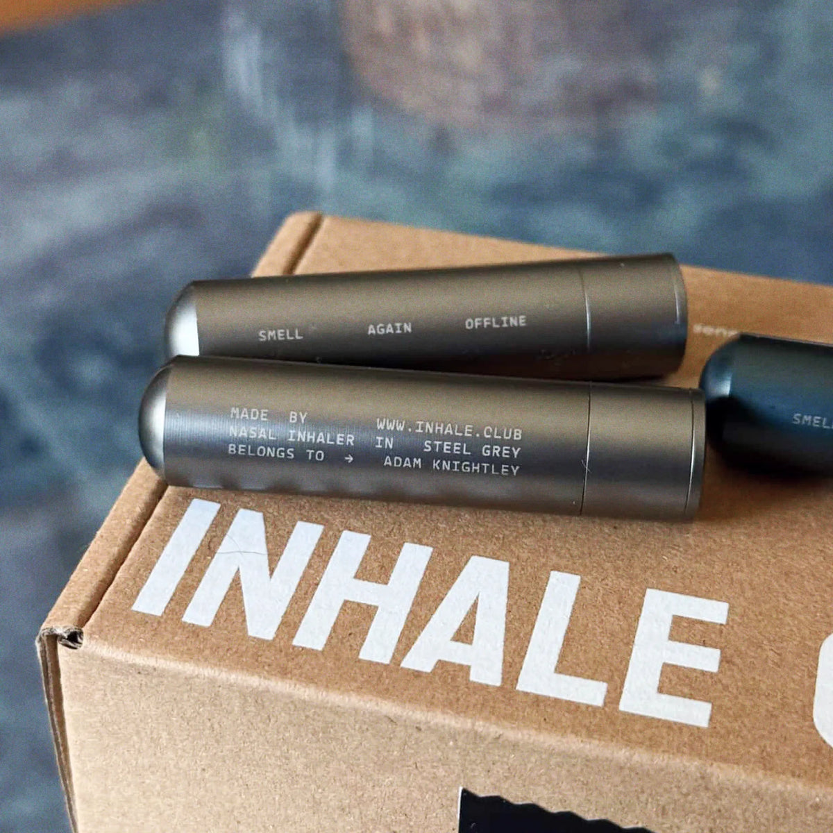 Aluminium inhalers resting on an Inhale Club box